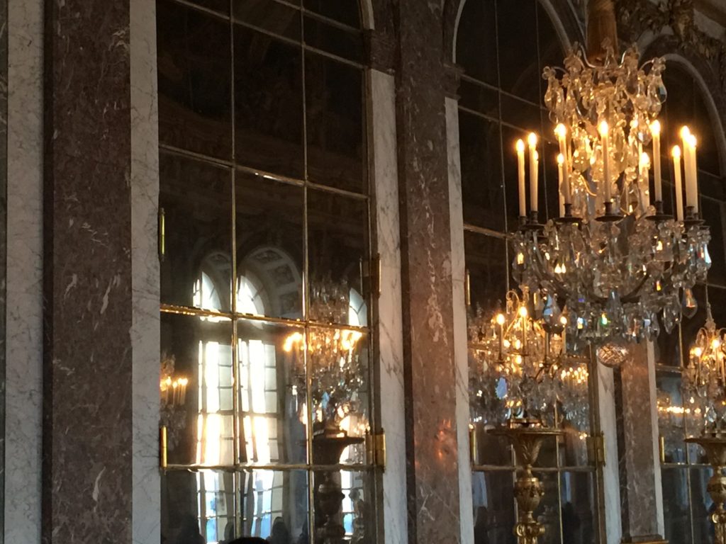 Lit chandelier in the hall with floor to ceiling mirrors