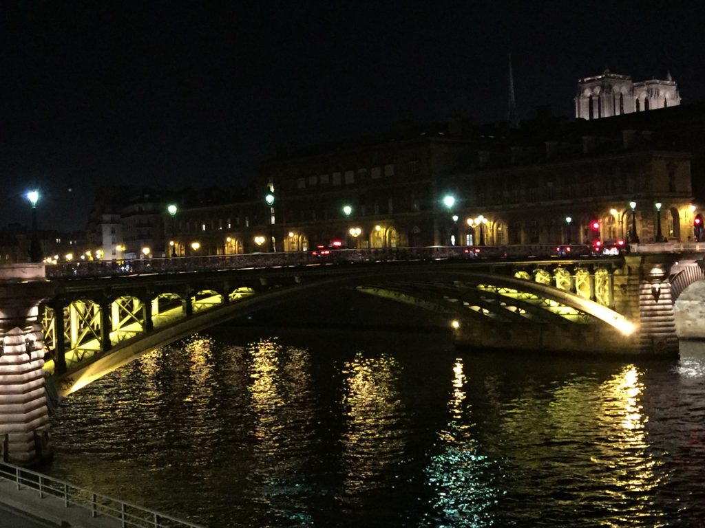 Arched, lit bridge at night over a river