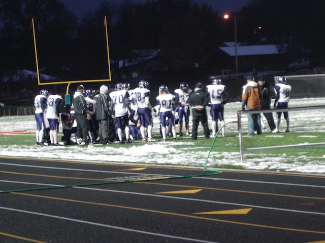 Football players in a huddle planning